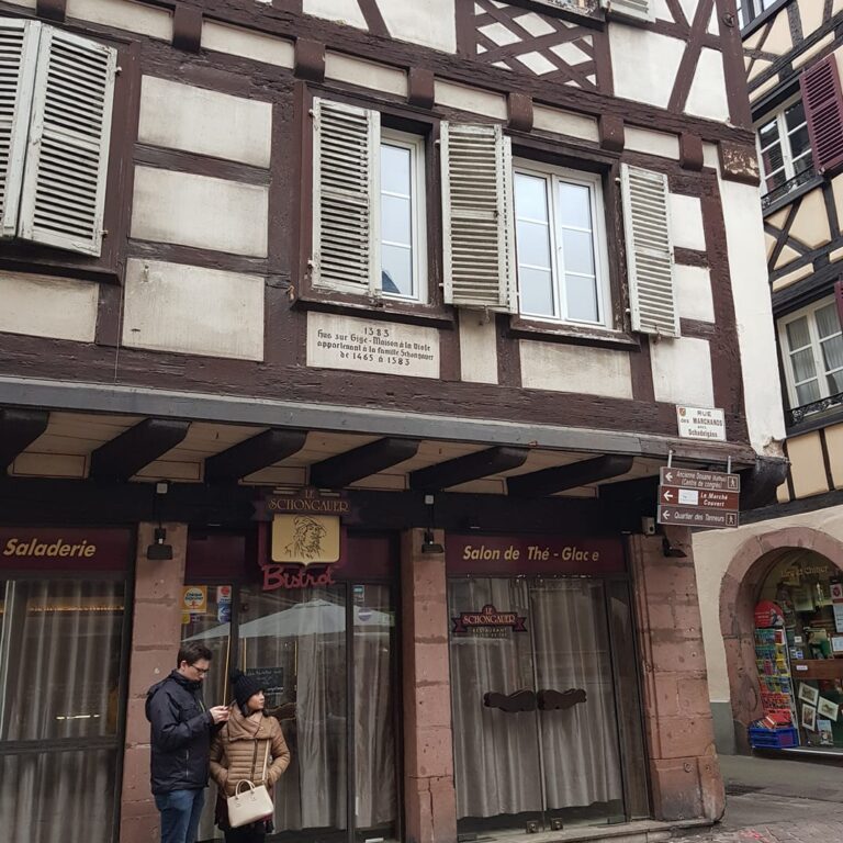 זוג צרפתי על רקע בית עתיק שהפך לבוטיק אופנתי