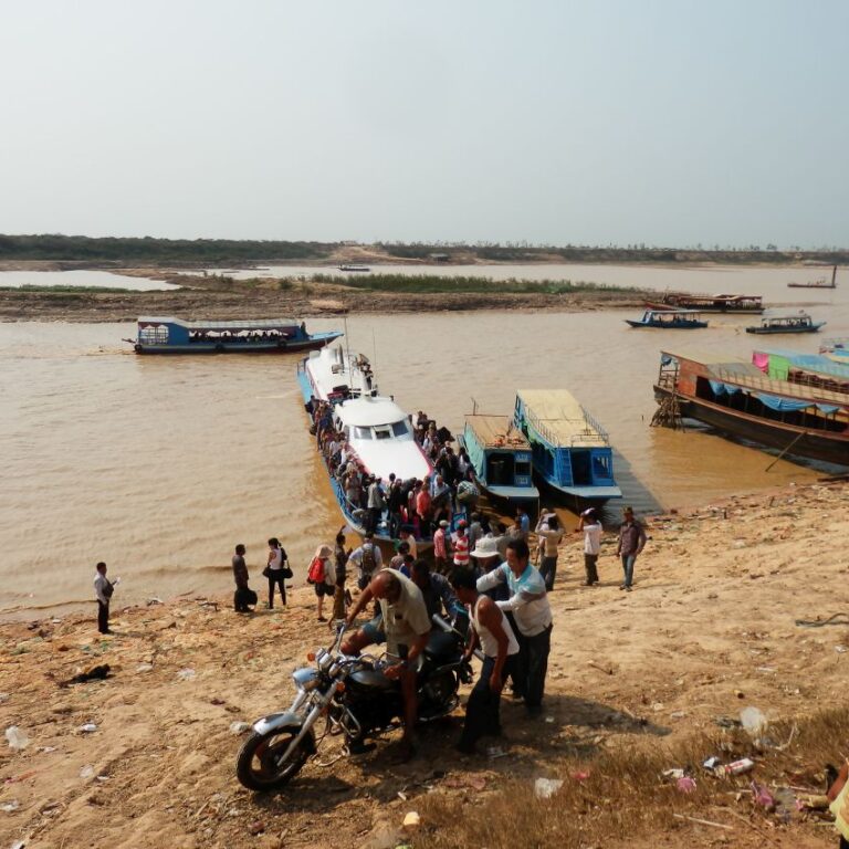 חבורת קמבודים נרתמת להעלאת אופנוע של זוג שוויצרי המטייל בעזרתו סביב העולם