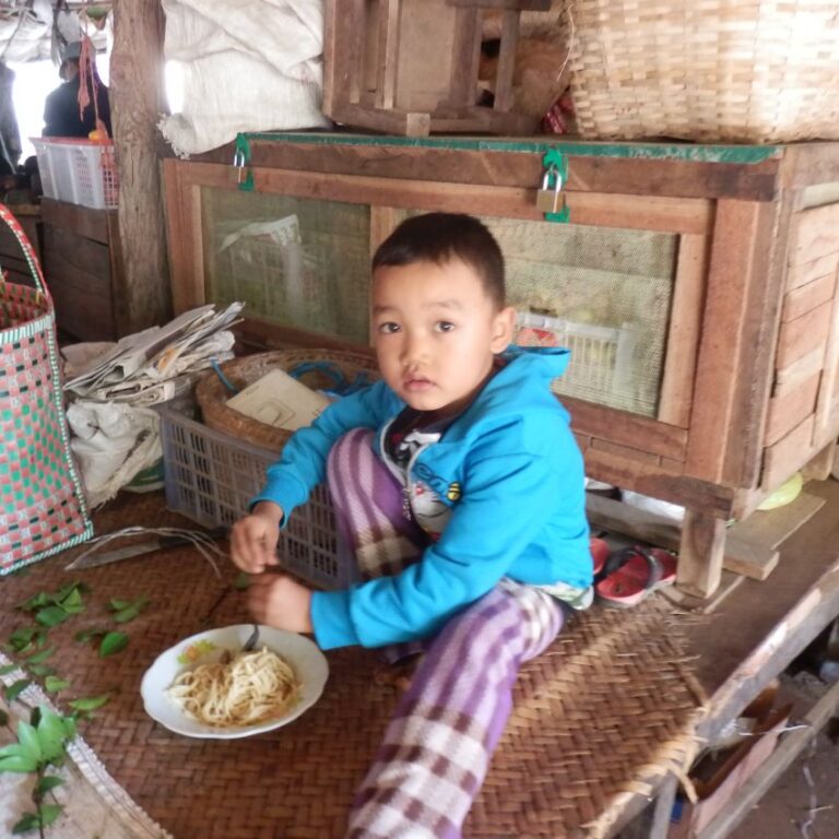 ילד סועד ליד דוכן הוריו בשוק