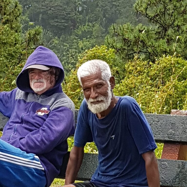 זוג קשישים באי מאורציוס הנחים בפארק ליד לוע הר געש מקומי