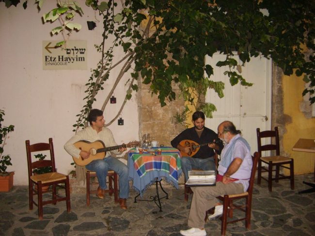 זמרים בחאניה בכרתים עם שלט המכוון לבית הכנסת ששרד