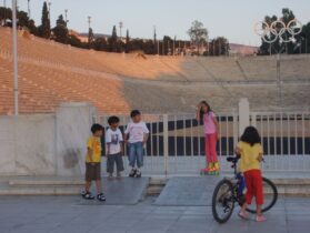 ילדים משחקים על רקע האיצטדיון באתונה