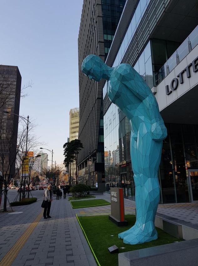 פסל של אדם משתחווה בכניסה למלון בסיאול