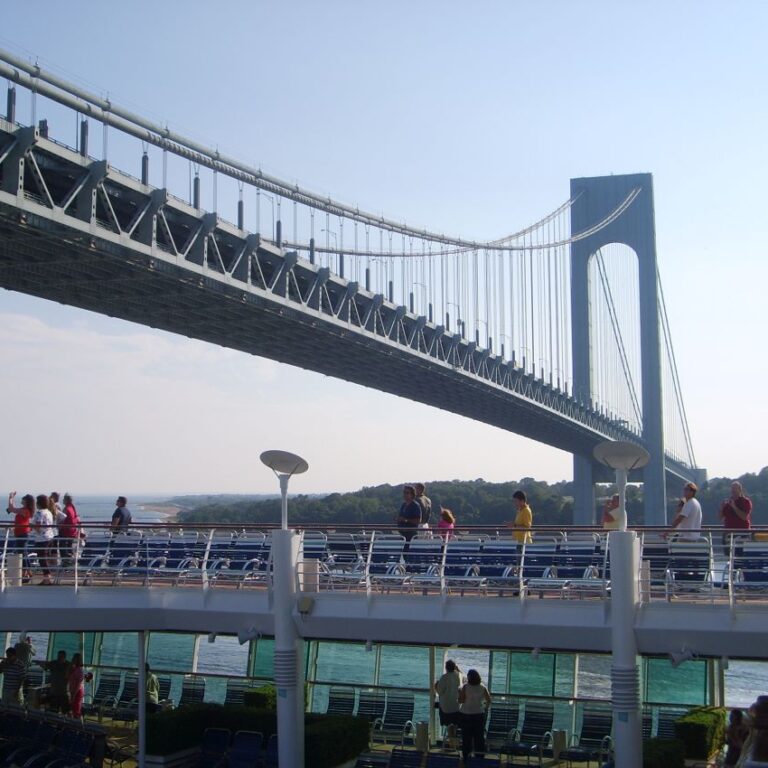 הספינה מפליגה לנמל ניו יורק מתחת לגשר ורזאנו המחבר את העיר לסטייטן איילנד