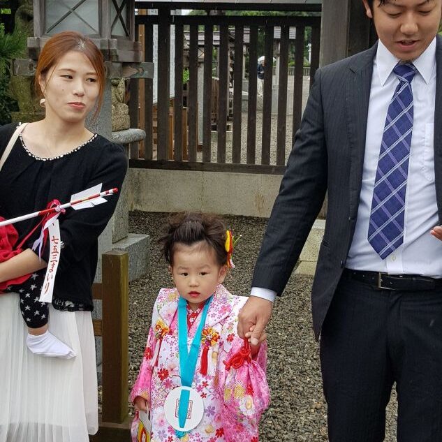 משפחה יפנית גאה מביאה את בתם לטקס במקדש שינטו