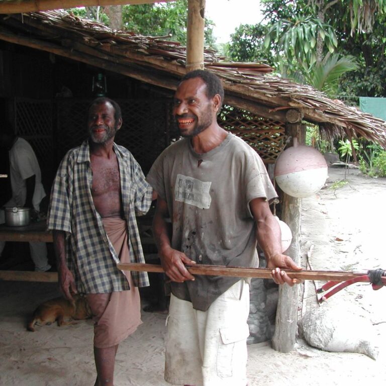 פפואני יליד ההרים מראה את כלי הנשק לציד דגים