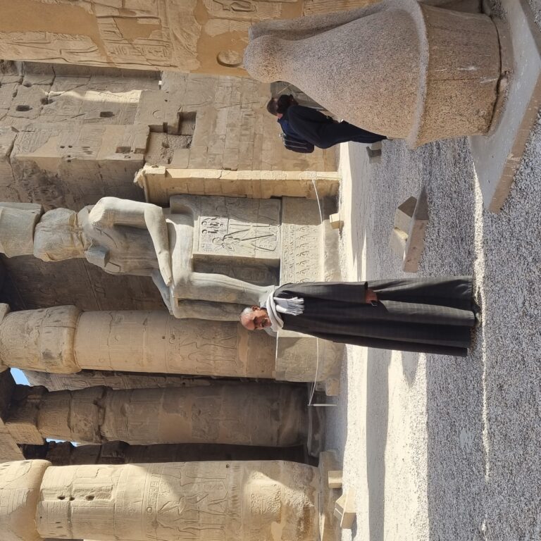 מצרי של היום ניצב בלוקסור למרגלות פסלו של רעמסס השני