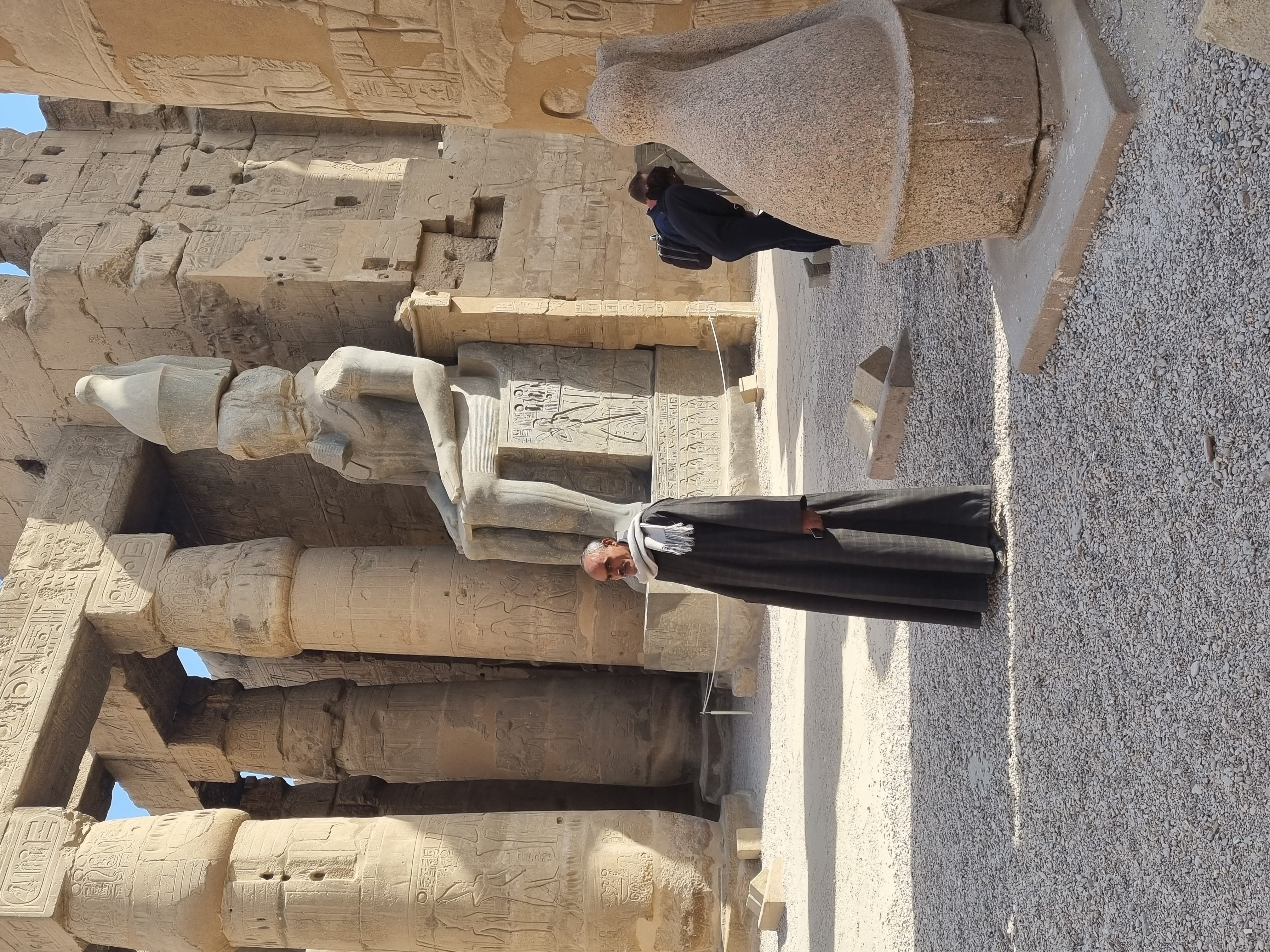 מצרי של היום ניצב בלוקסור למרגלות פסלו של רעמסס השני
