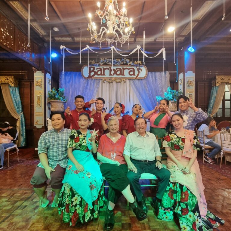 יושבים עם להקת הריקוד הפיליפינית שהופיעה בפני קהל הסועדים במועדון הלילה במנילה