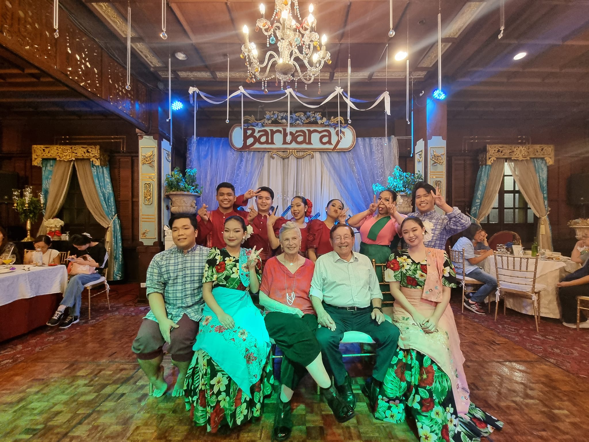 יושבים עם להקת הריקוד הפיליפינית שהופיעה בפני קהל הסועדים במועדון הלילה במנילה