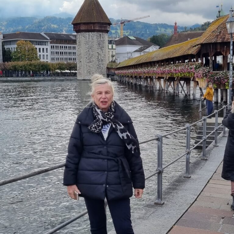 צביה על רקע גשר לוצרן שעלה בזמנו באש ושופץ